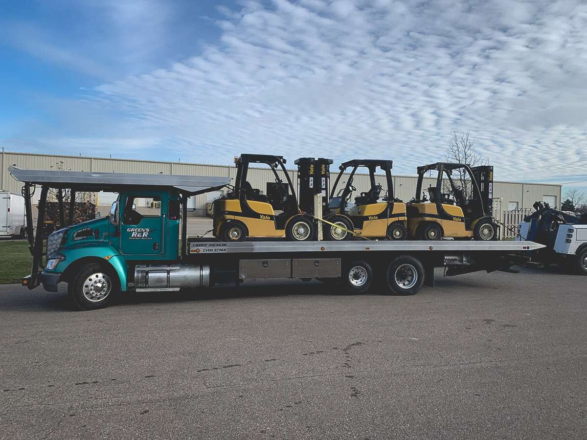 Tracked skid steer with a large winch box on the front for towing and recovery.