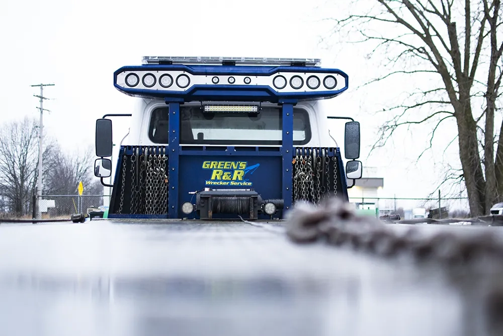 The back of a flatbed tow truck that says Green's R&R Wrecker Service.